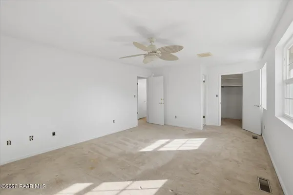 a view of an empty room with a ceiling fan