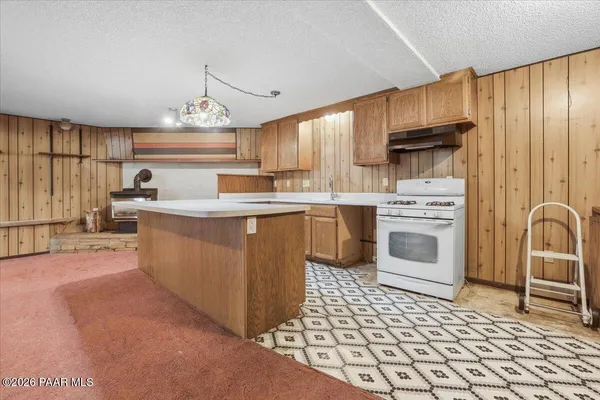 a kitchen with stainless steel appliances a stove a sink and cabinets
