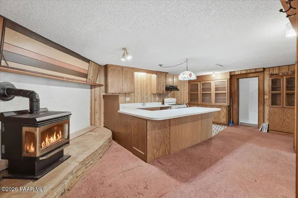 a large kitchen with stainless steel appliances granite countertop a lot of counter space and a sink
