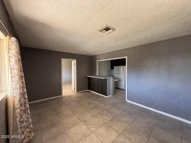 a view of a livingroom with a kitchen space and a window
