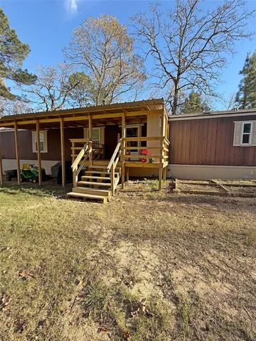 a view of a house with a yard and furniture
