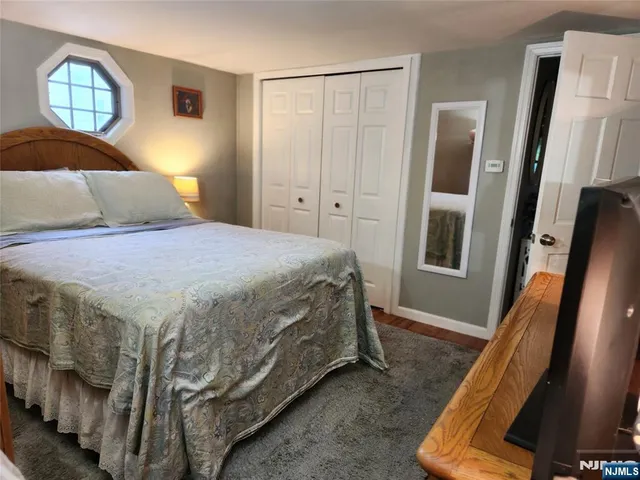 a bedroom with a bed window and mirror