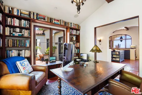 a living room with furniture and a book shelf