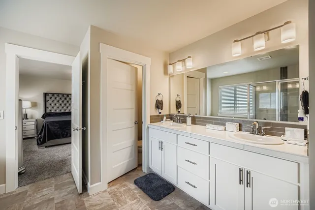 a bathroom with a double vanity sink and a mirror