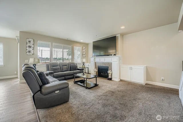 a living room with furniture a fireplace and a flat screen tv