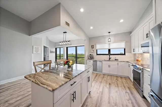 a kitchen with stainless steel appliances granite countertop a stove and cabinets