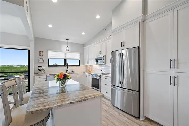 a kitchen with stainless steel appliances a refrigerator sink and microwave