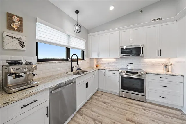a kitchen with stainless steel appliances granite countertop a sink and a stove