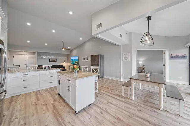 a large white kitchen with lots of counter space a sink appliances and cabinets