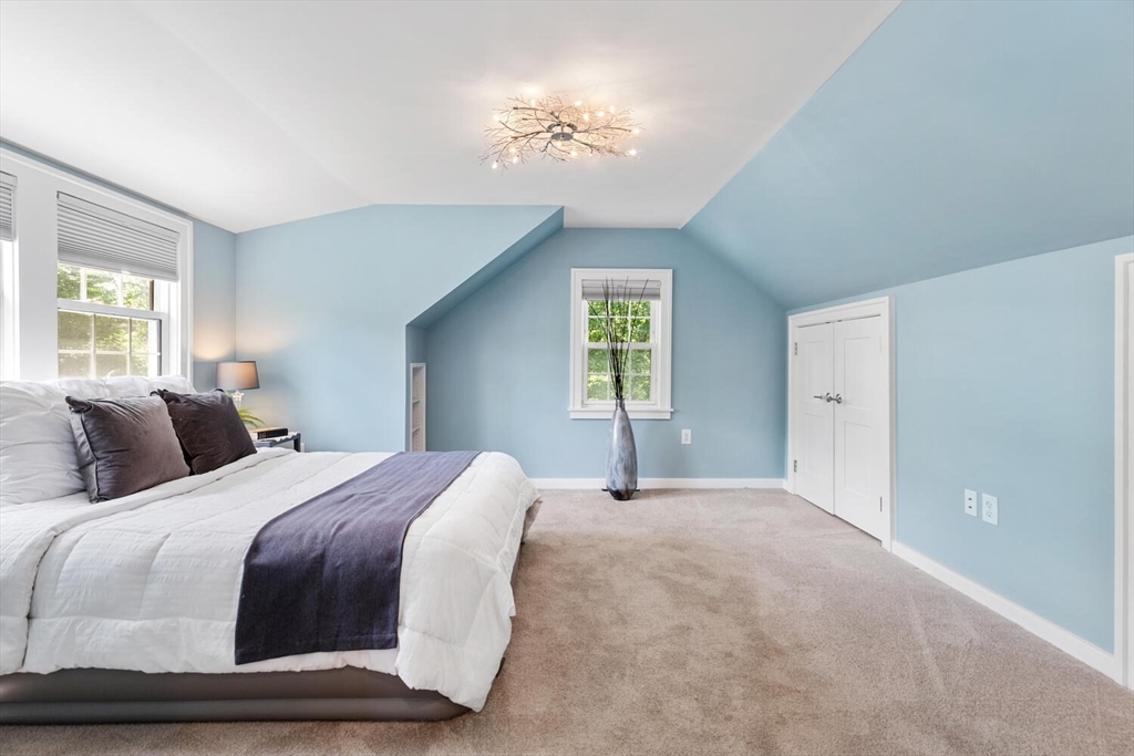 10 Wolcott Street Wakefield, MA 01880 - Photo 22 of 42 a bedroom with a bed and a chandelier