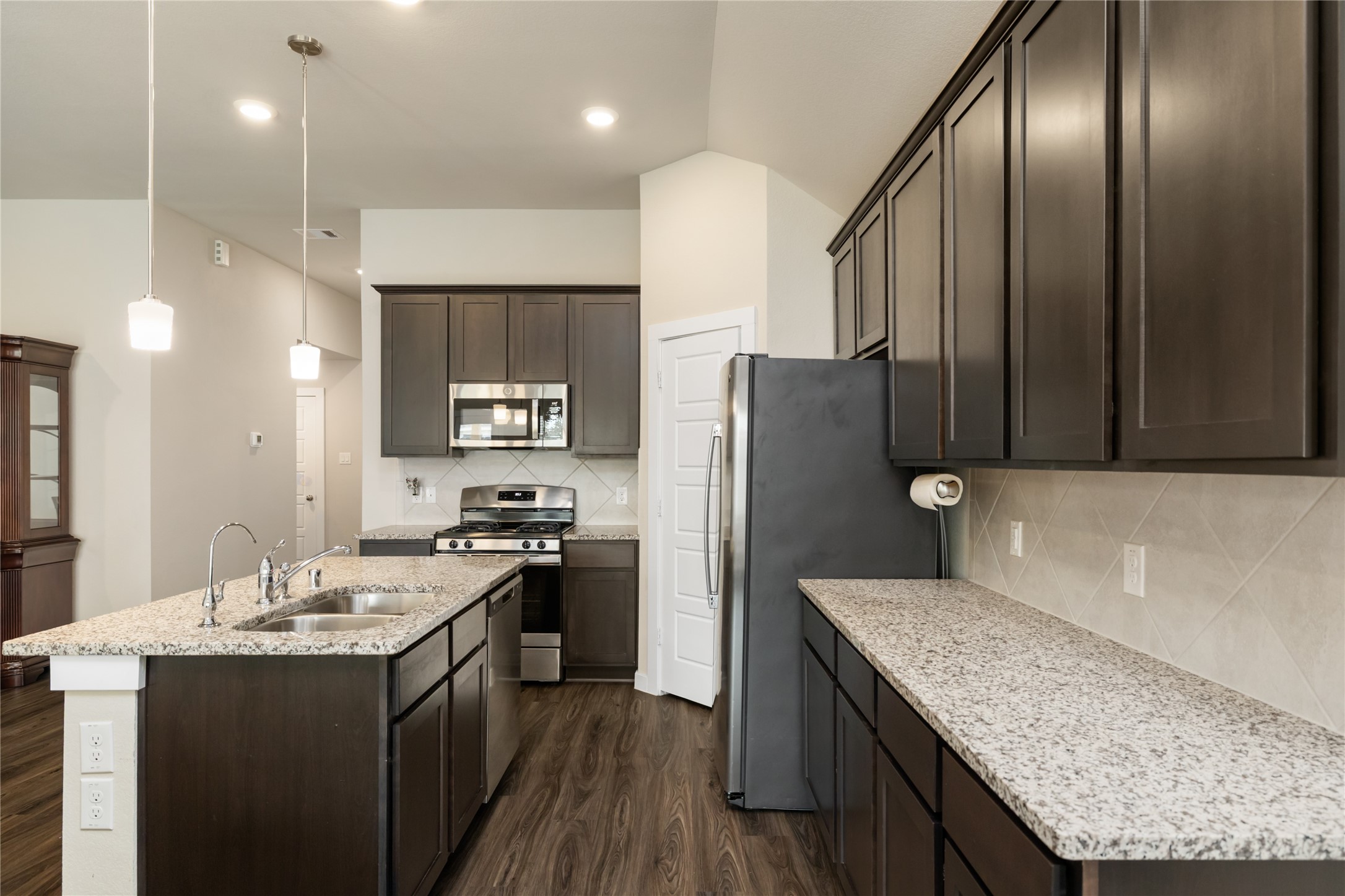 7622 Mistral Lane Baytown, TX 77523 - Photo 9 of 25 Kitchen is finished with stainless steel appliances, granite countertops, and modern shaker style cabinetry