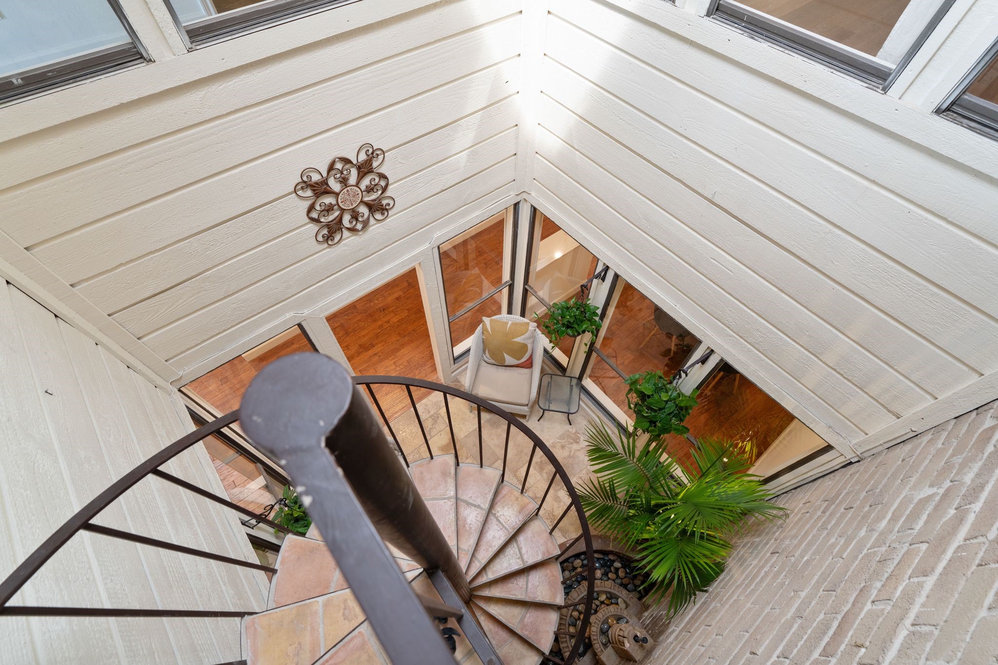 153 Sage Road Houston, TX 77056 - Photo 30 of 36 A look down the enclosed atrium and spiral staircase connecting. There is also a main set of stairs for the 2nd floor.