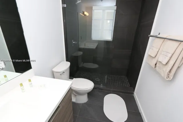 a bathroom with a toilet a sink and mirror