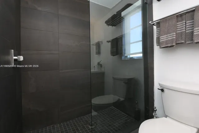 a bathroom with a toilet and a shower