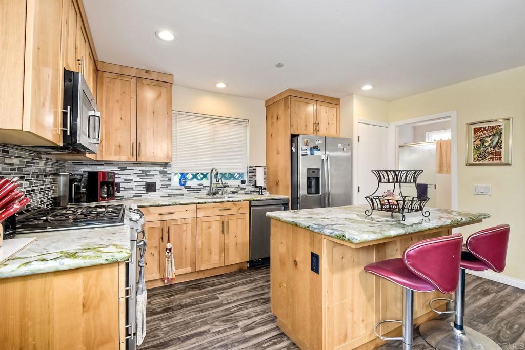 476 La Veta Avenue Encinitas, CA 92024 - Photo 18 of 24 a kitchen with stainless steel appliances granite countertop a sink stove and refrigerator
