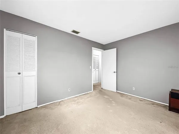 a spacious bedroom with a bed and a chandelier