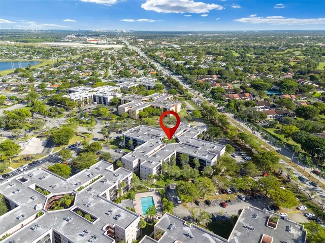an aerial view of residential houses with outdoor space and trees