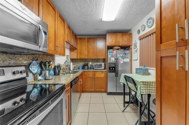 a kitchen with stainless steel appliances granite countertop a stove and a refrigerator