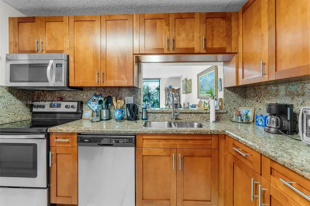 a kitchen with stainless steel appliances granite countertop a sink and cabinets