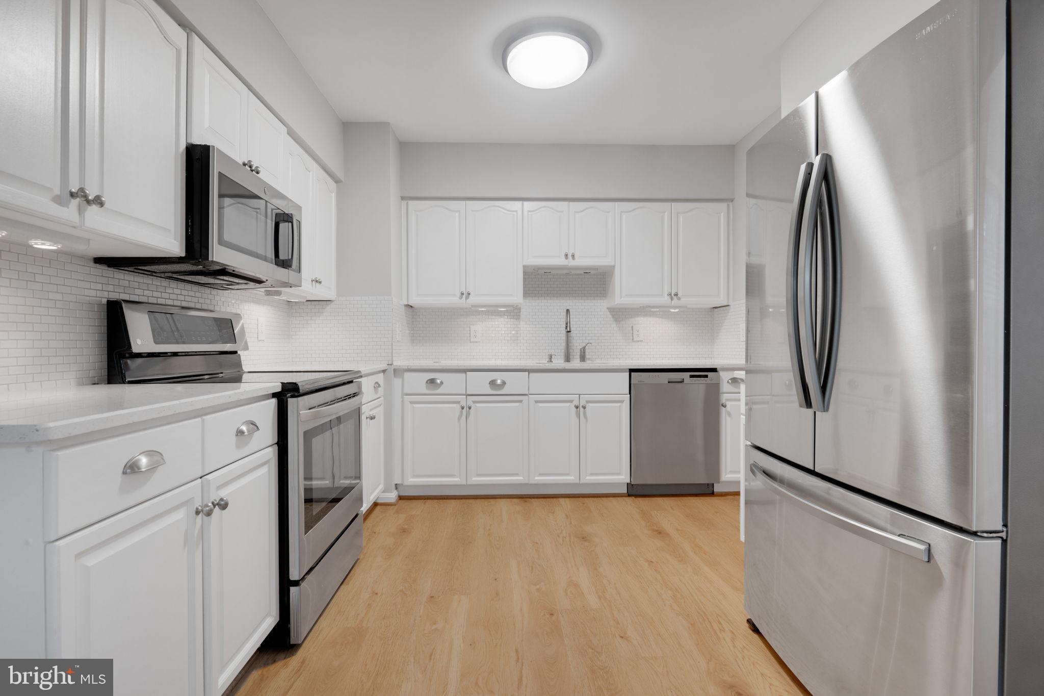 7267 Olde Lantern Way Springfield, VA 22152 - Photo 11 of 52 a kitchen with stainless steel appliances a refrigerator sink and microwave