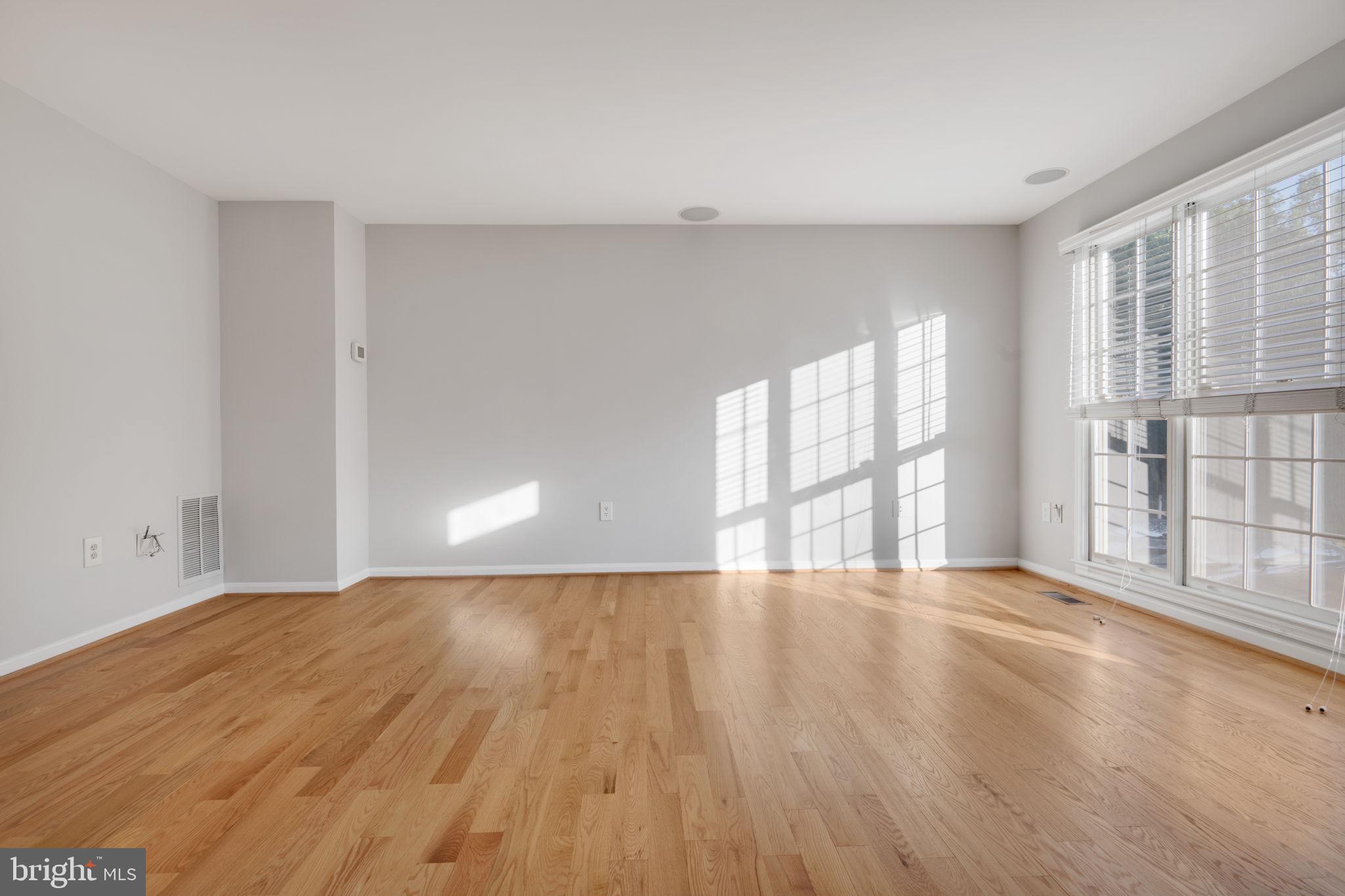 7267 Olde Lantern Way Springfield, VA 22152 - Photo 5 of 52 a view of an empty room with wooden floor and a window