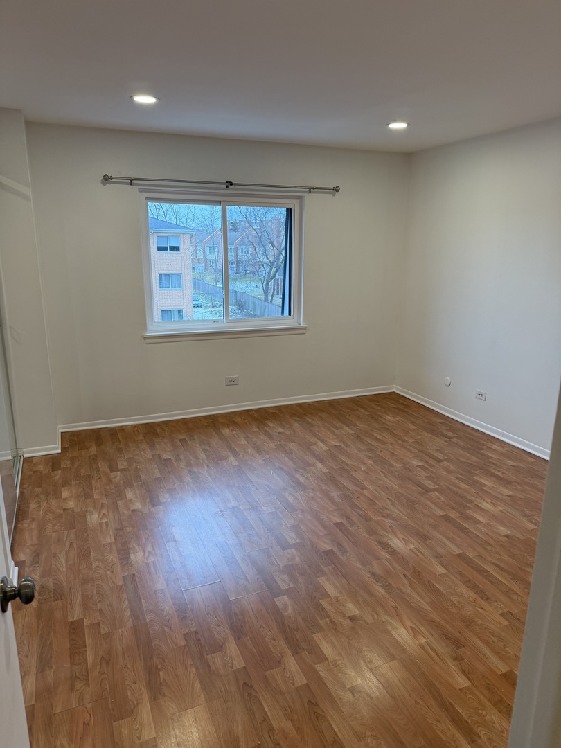 4208 Central Road, Unit 4F Glenview, IL 60025 - Photo 8 of 11 an empty room with wooden floor and windows