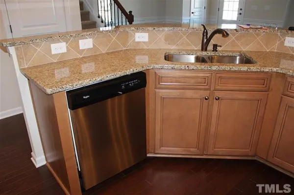 a kitchen with granite countertop a sink and cabinets
