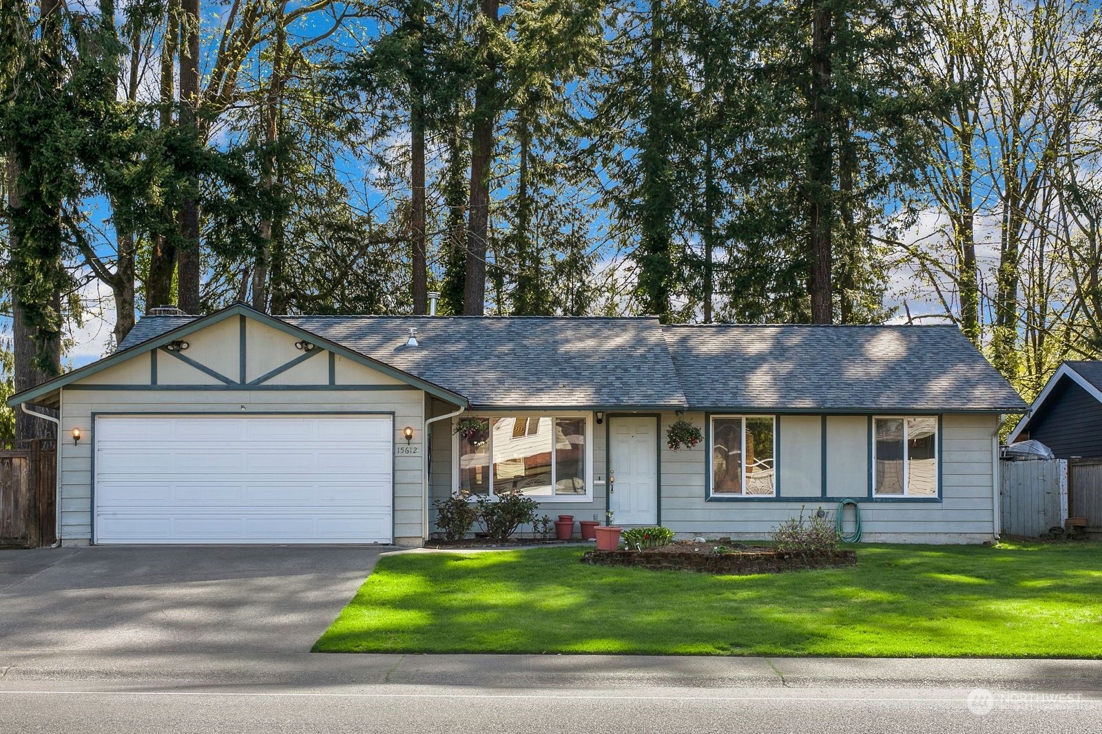 a front view of a house with a garden and trees
