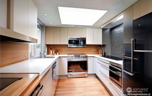 a kitchen with granite countertop stainless steel appliances a stove top oven and sink