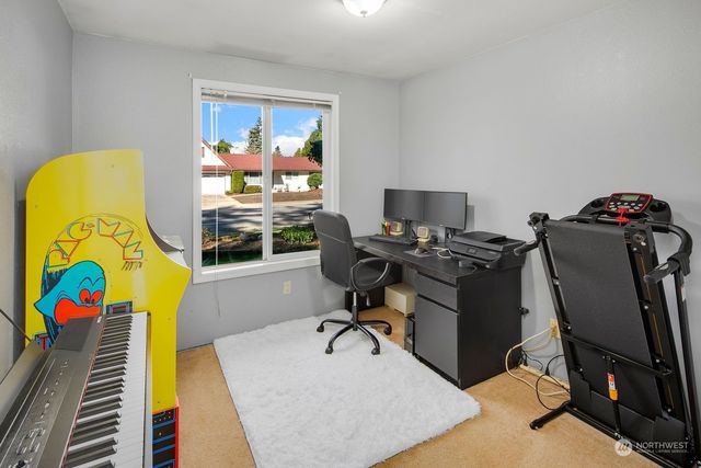 a view of a workspace with furniture and a window