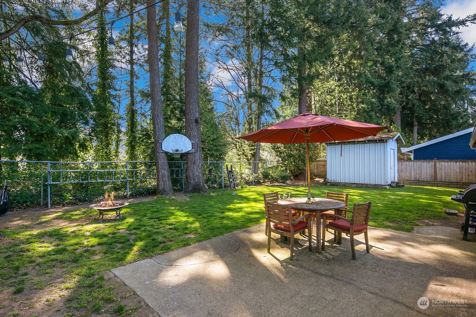 15612 119th Avenue Northeast Bothell, WA 98011 - Photo 26 of 32 a view of a table and chairs under an umbrella in backyard