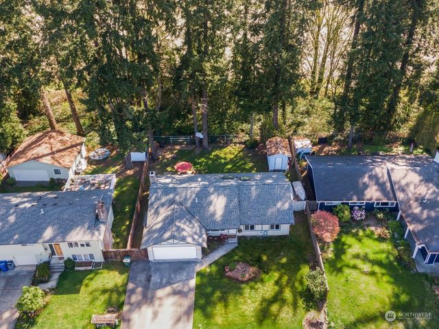 an aerial view of a house with a yard and large trees