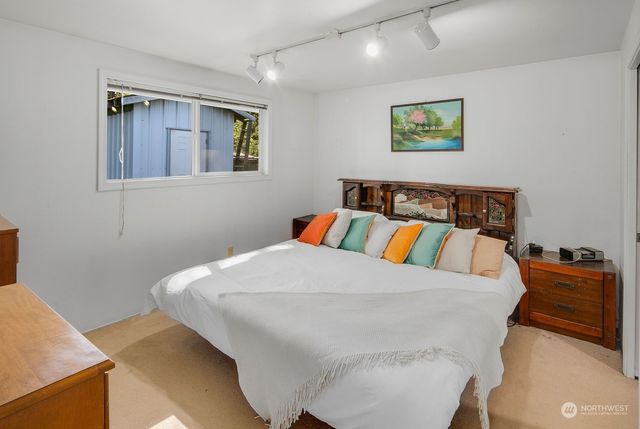 a bedroom with a bed and painting on the wall