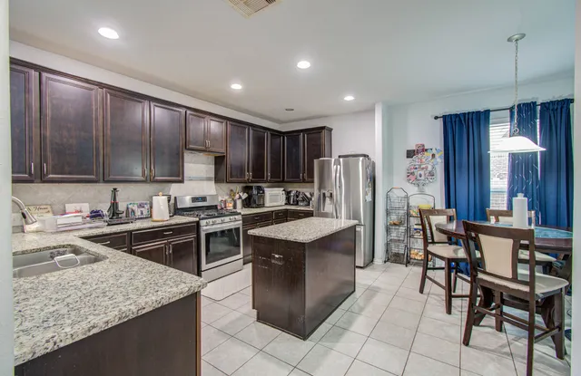 a kitchen with cabinets and chairs