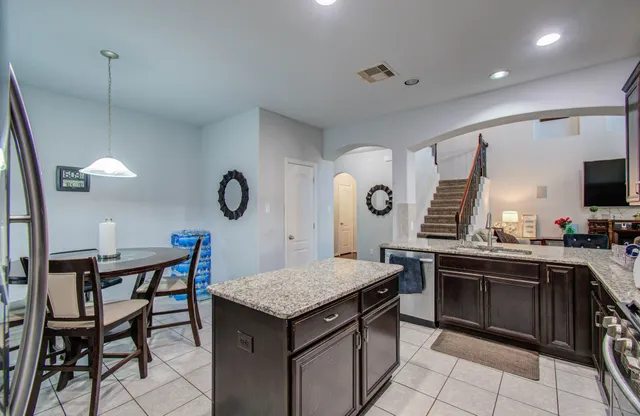 a kitchen with a table chairs sink and cabinets