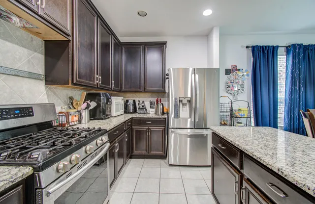 a kitchen with granite countertop stainless steel appliances and wooden cabinets