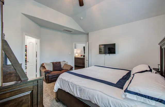 a bedroom with a bed a couch and dresser