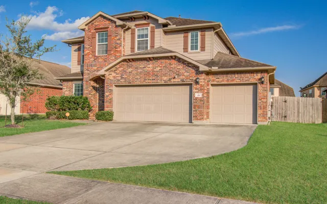 a front view of a house with a garden and garage