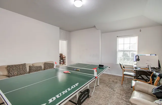 a living room with a table and a pool table