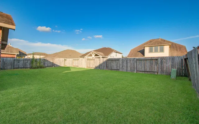 a view of a wooden fence with a view of a house