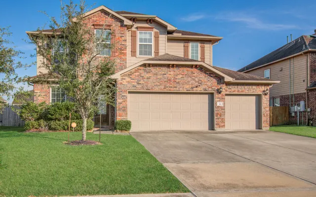 a front view of a house with a garden and trees