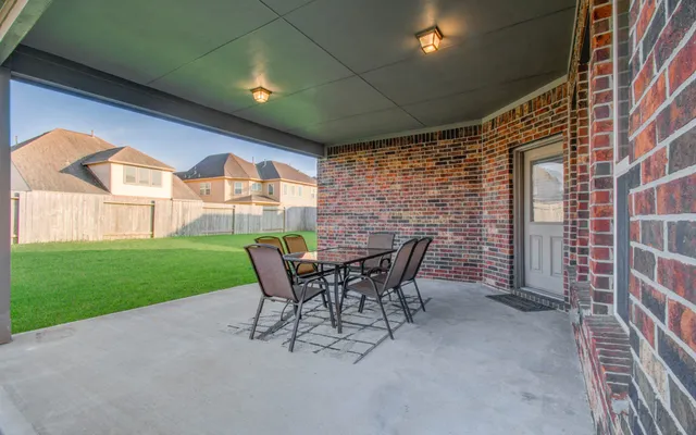 a view of a patio with table and chairs and garden