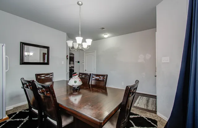 a view of a dining room with furniture and chandelier