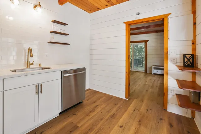 a kitchen with a sink cabinets and wooden floor