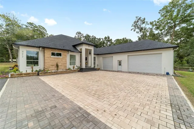 a view of a yard in front of a house with large tree