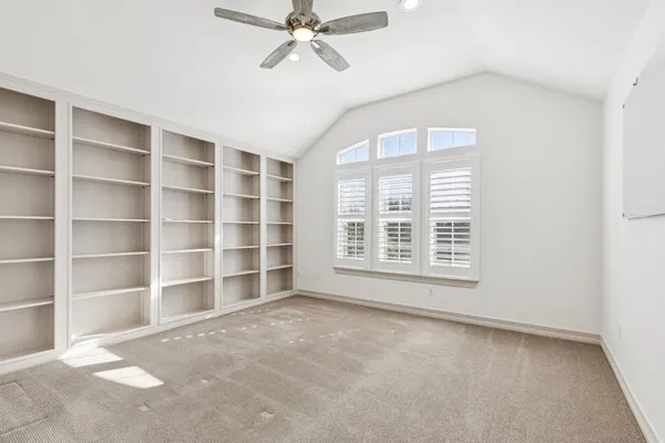 a view of an empty room with a window and cabinet