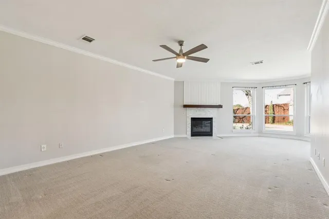 an empty room with windows and fireplace