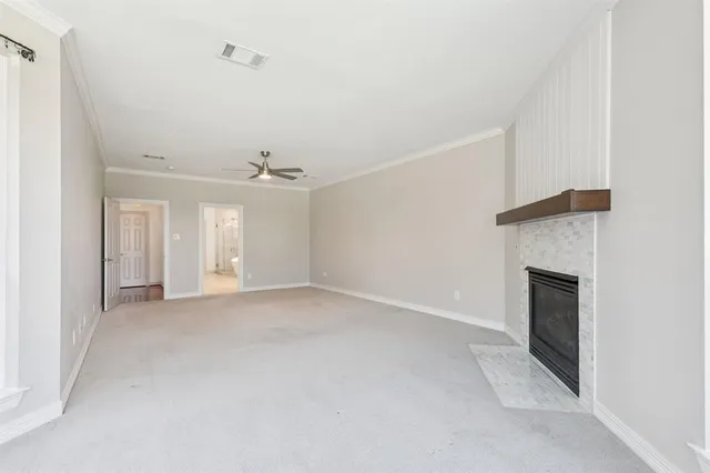 an empty room with windows and fireplace