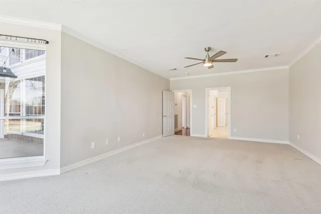 an empty room with a ceiling fan and window
