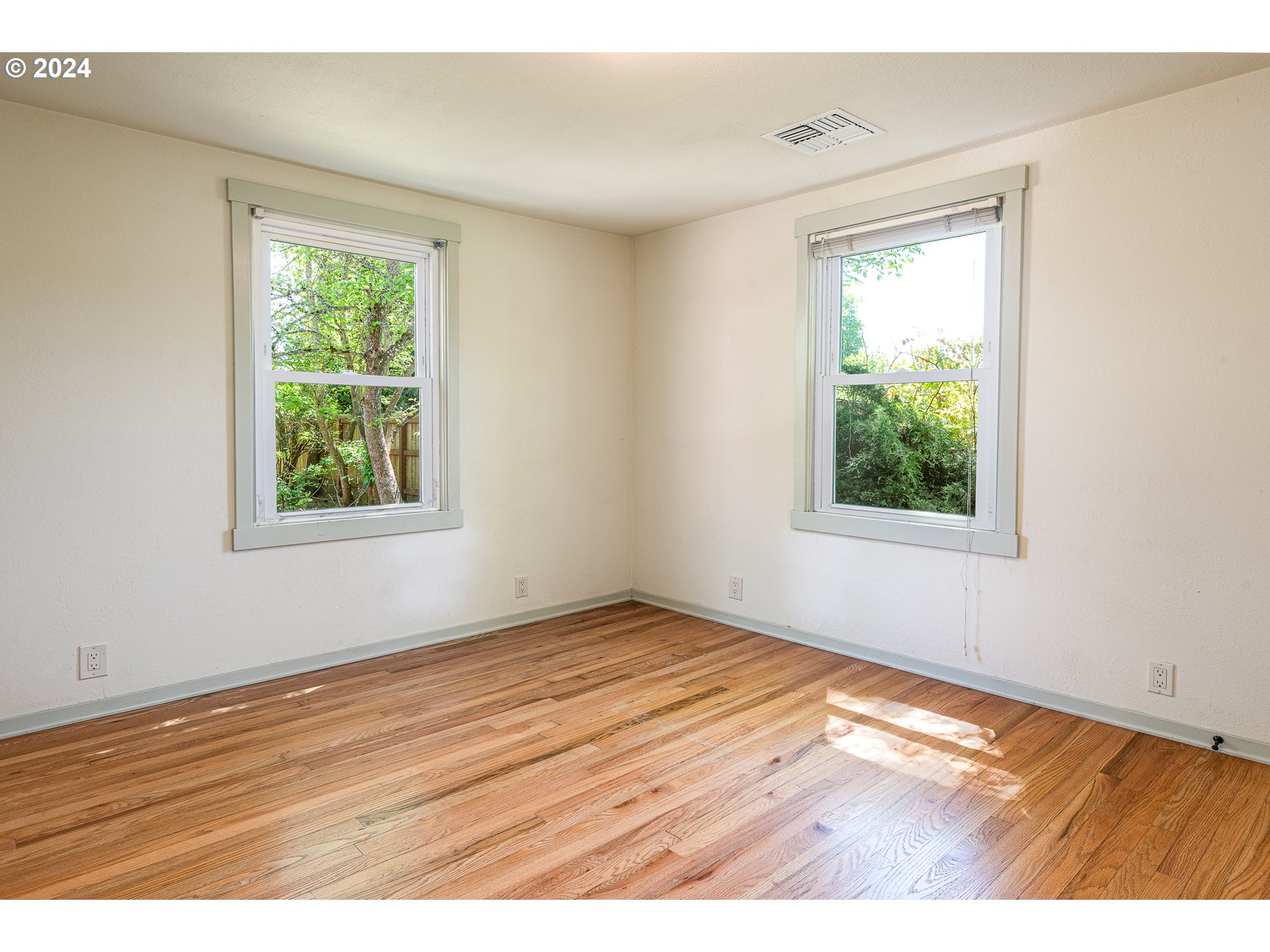 2915 Mill Street Eugene, OR 97405 - Photo 19 of 37 an empty room with wooden floor and windows